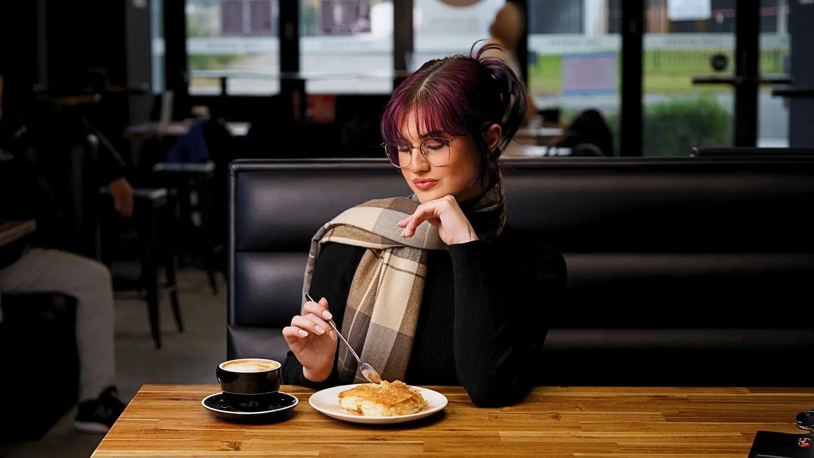 Woman enjoying galaktoboureko and coffee at The Sphere in Cheltenham, Melbourne
